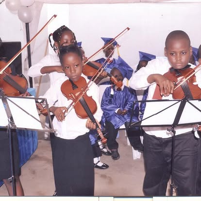 Children playing violins indoors